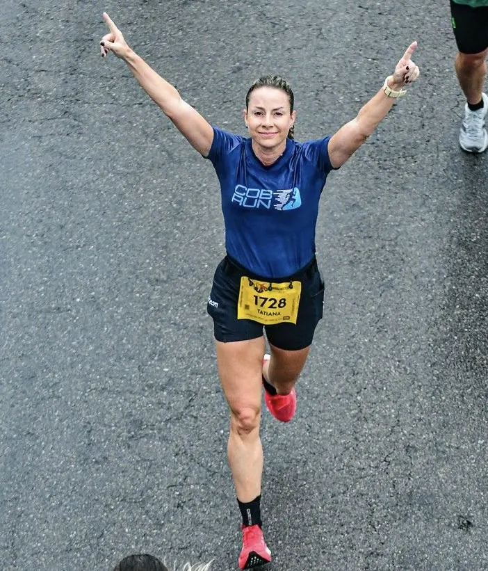 Atleta da COB Run comemorando de braços erguidos